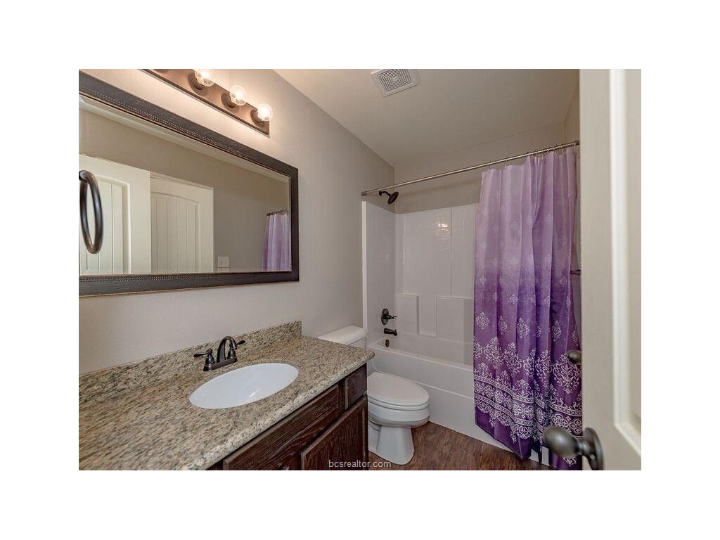 131 Watson Lane Bryan, TX 77801 - Photo 16 of 20 Full bathroom featuring hardwood / wood-style flooring, vanity, shower / bath combination with curtain, and toilet