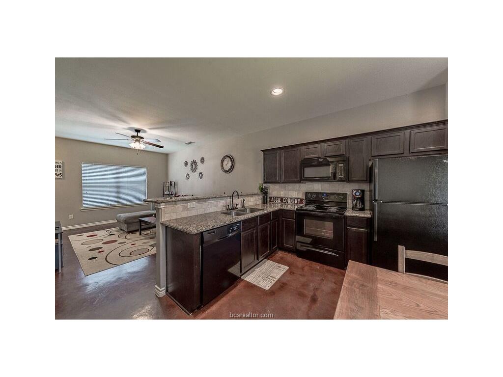 131 Watson Lane Bryan, TX 77801 - Photo 5 of 20 Kitchen featuring sink, ceiling fan, black appliances, light stone countertops, and dark brown cabinets