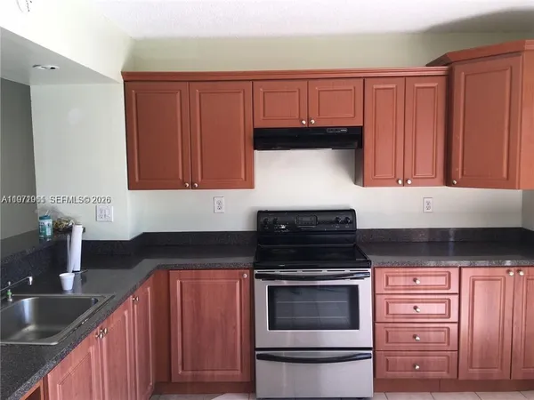 a kitchen with granite countertop wood cabinets and stainless steel appliances
