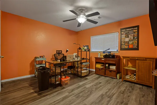 a view of a workspace with furniture and wooden floor