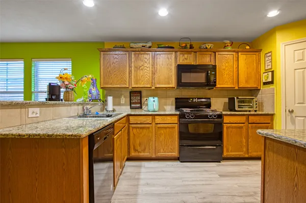 a kitchen with stainless steel appliances granite countertop a stove a sink and a microwave