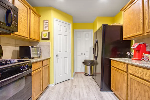 a kitchen with stainless steel appliances granite countertop a refrigerator and a stove top oven