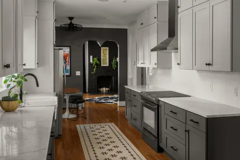 a kitchen with stainless steel appliances granite countertop a refrigerator a stove and a sink with wooden floor