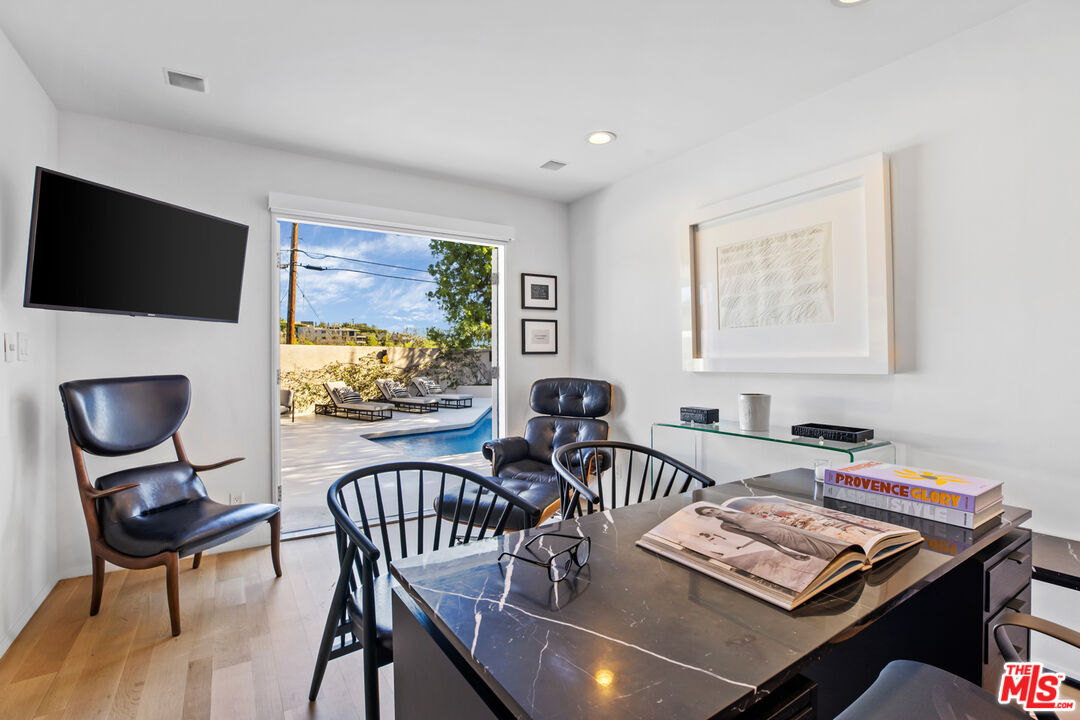 9271 Flicker Way Los Angeles, CA 90069 - Photo 14 of 28 a view of a dining room with furniture a rug and wooden floor