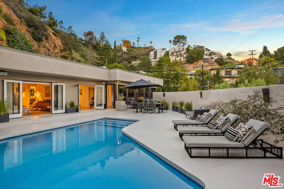 9271 Flicker Way Los Angeles, CA 90069 - Photo 24 of 28 a view of a patio with couches table and chairs with potted plants and large tree