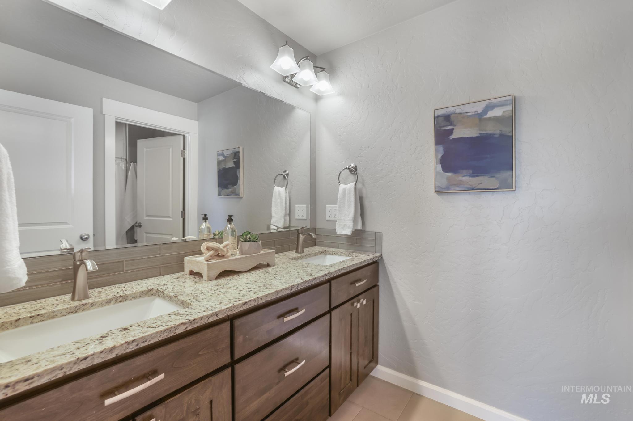 2858 Sunray Loop Twin Falls, ID 83301 - Photo 29 of 45 Bathroom featuring a textured wall, double vanity, and light tile patterned flooring