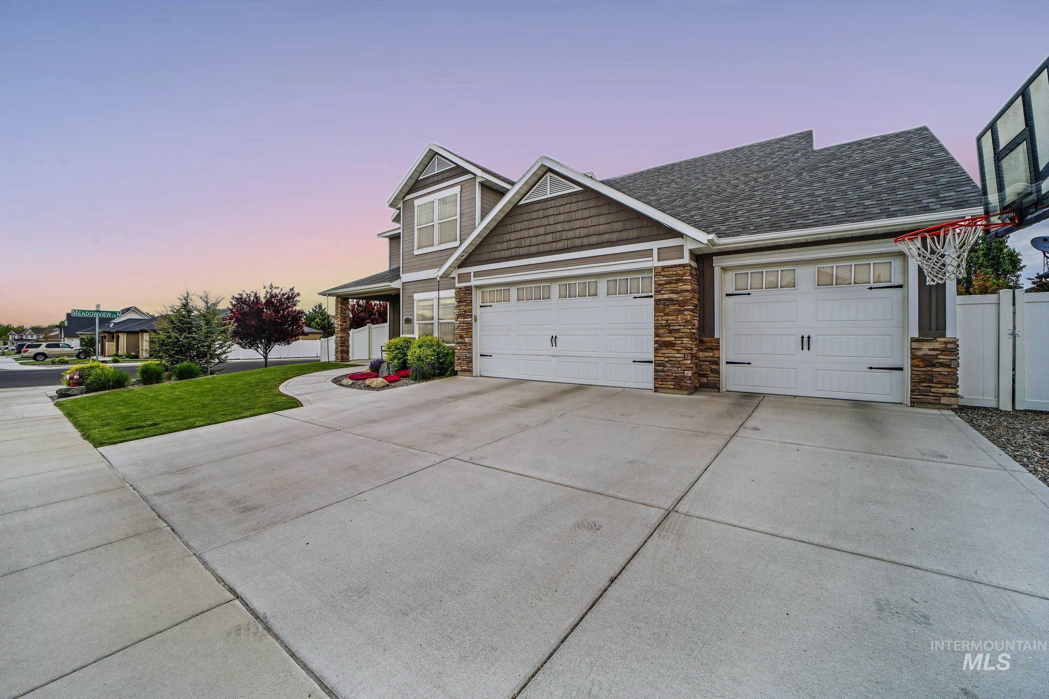 2858 Sunray Loop Twin Falls, ID 83301 - Photo 3 of 45 View of front of home featuring driveway, stone siding, an attached garage, and roof with shingles
