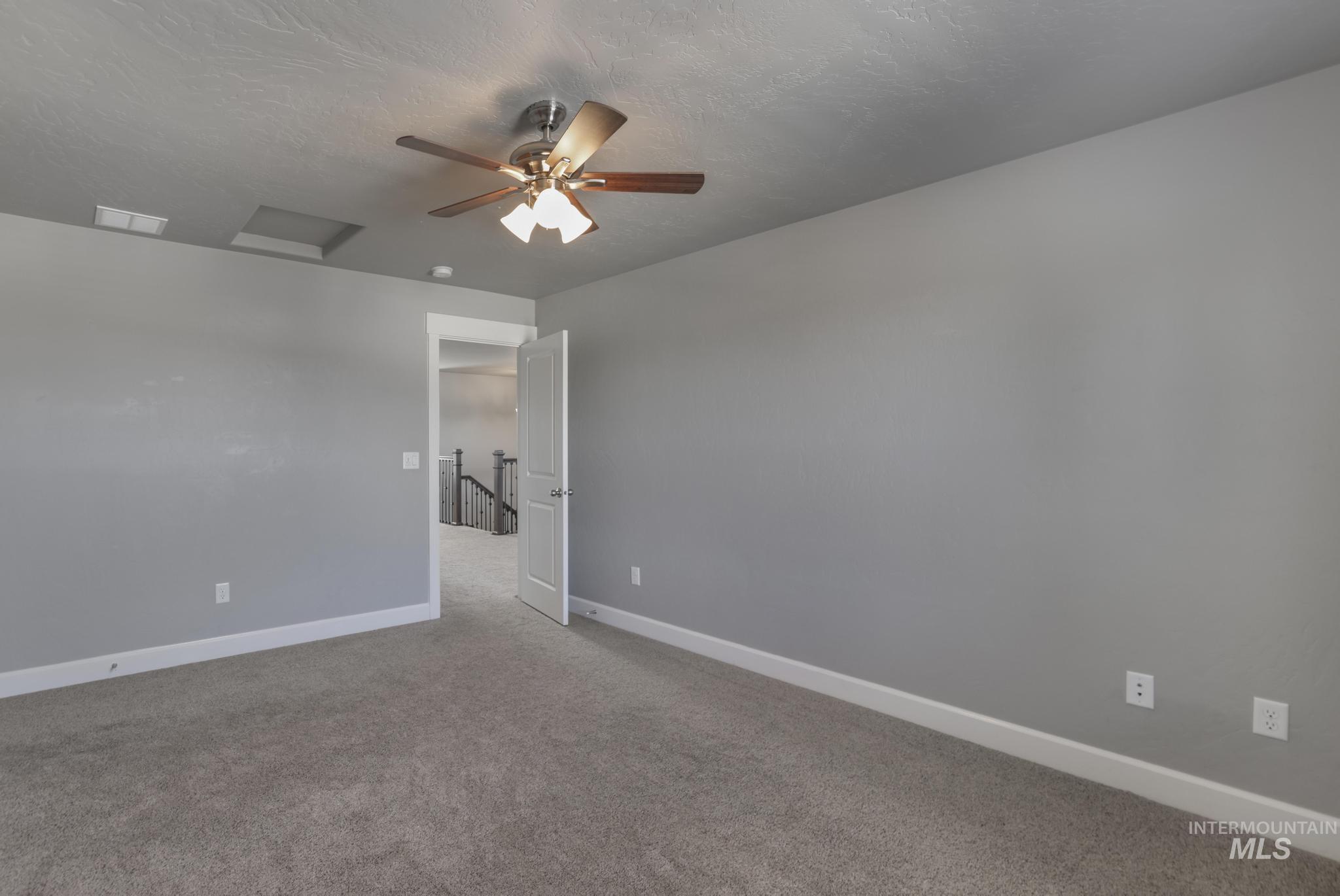 2858 Sunray Loop Twin Falls, ID 83301 - Photo 32 of 45 Spare room with carpet floors, a textured ceiling, attic access, and ceiling fan