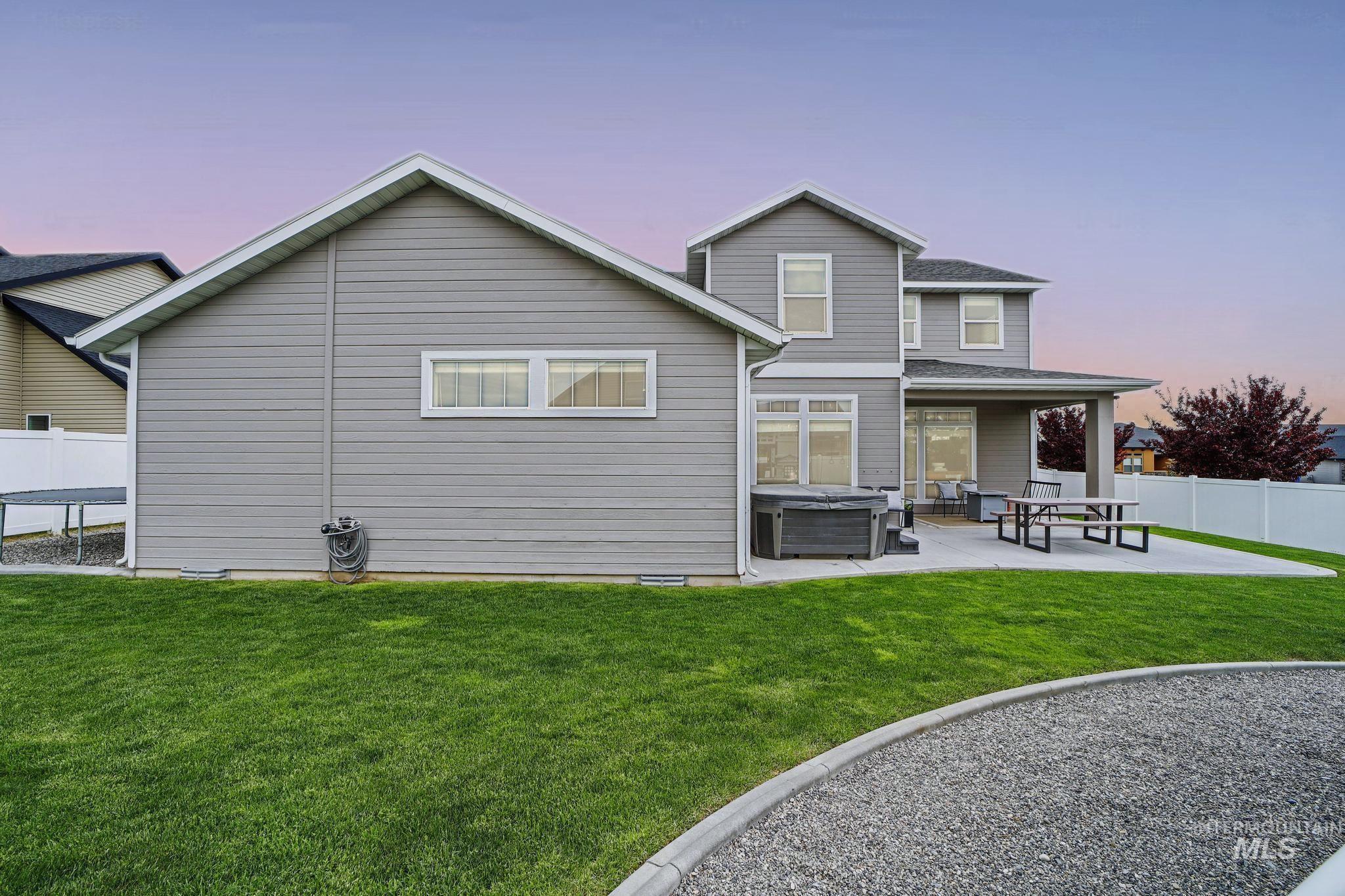 2858 Sunray Loop Twin Falls, ID 83301 - Photo 39 of 45 Back of house at dusk featuring a hot tub and a patio area