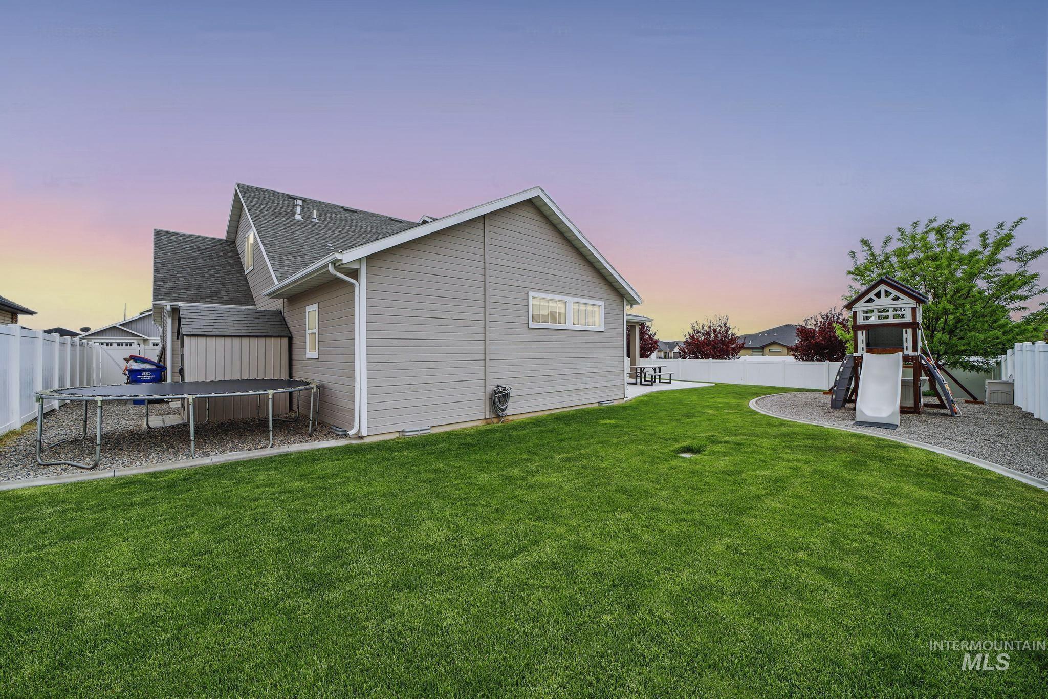 2858 Sunray Loop Twin Falls, ID 83301 - Photo 40 of 45 Back of house with a fenced backyard, a trampoline, a playground, and roof with shingles