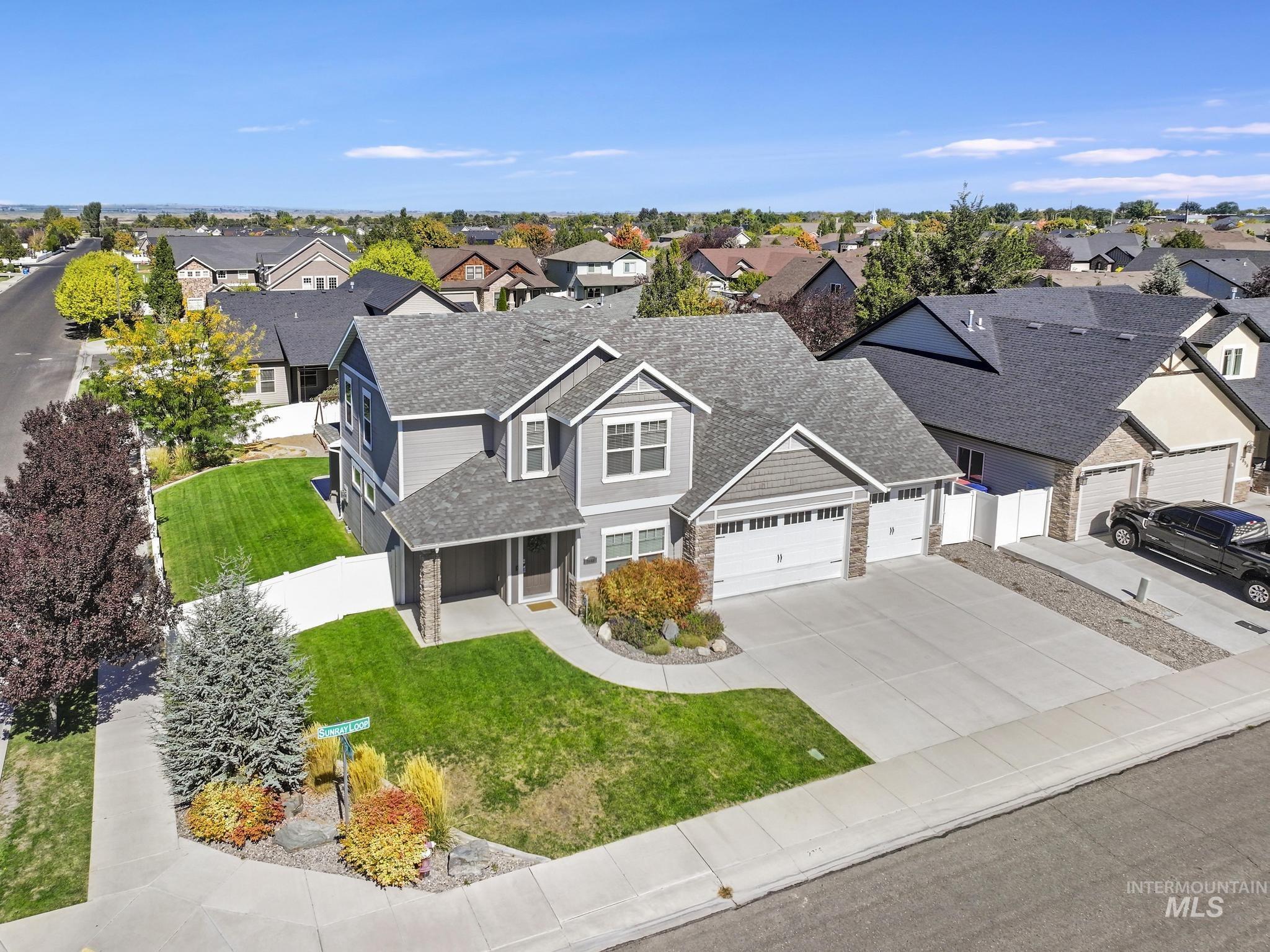 2858 Sunray Loop Twin Falls, ID 83301 - Photo 42 of 45 View of front of house featuring a shingled roof, driveway, stone siding, a porch, and an attached garage