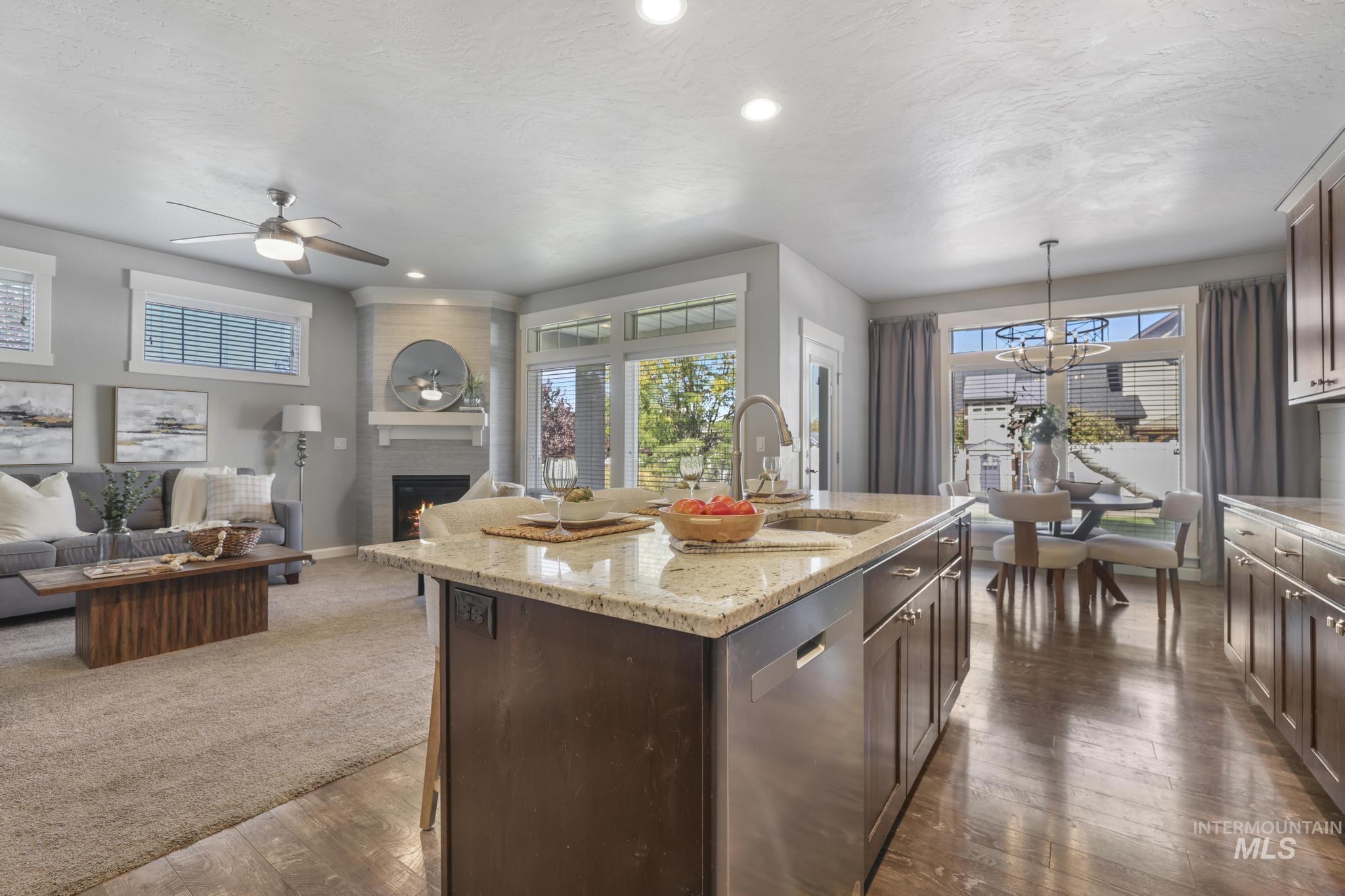 2858 Sunray Loop Twin Falls, ID 83301 - Photo 45 of 45 Kitchen featuring dishwasher, open floor plan, light stone countertops, dark brown cabinets, and a fireplace