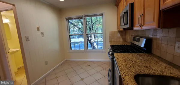 a bathroom with a granite countertop sink and a window