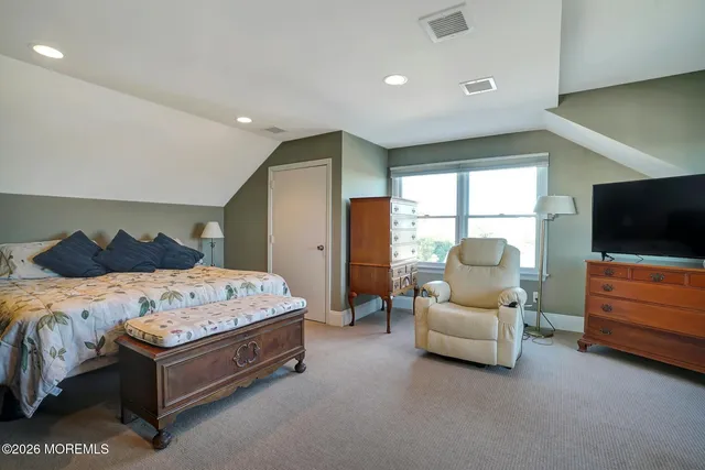 a spacious bedroom with a bed and a flat screen tv