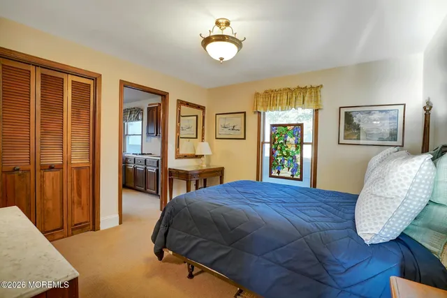 a bedroom with a bed and dresser with mirror