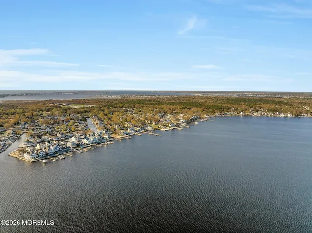 an aerial view of ocean and residential houses with outdoor space