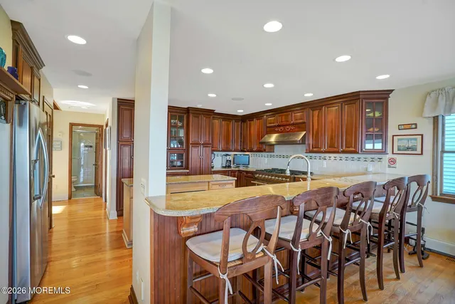 a front view of a house with a garden and lake view