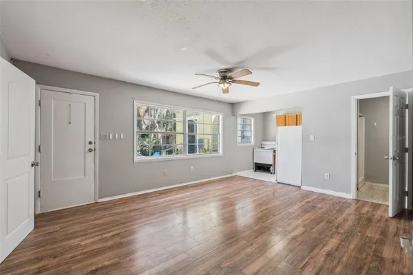a view of an empty room with a window and wooden floor