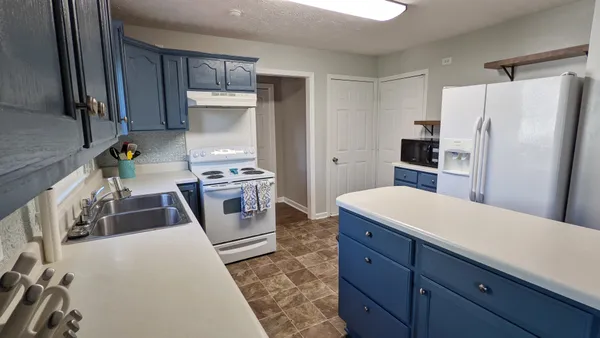 a kitchen with a refrigerator and a stove