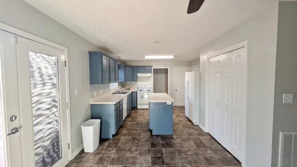 a kitchen with granite countertop a sink stove and refrigerator