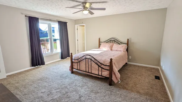 a bedroom with a bed dresser and a window