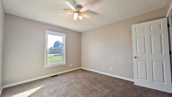 a bed sitting in a bedroom next to a window