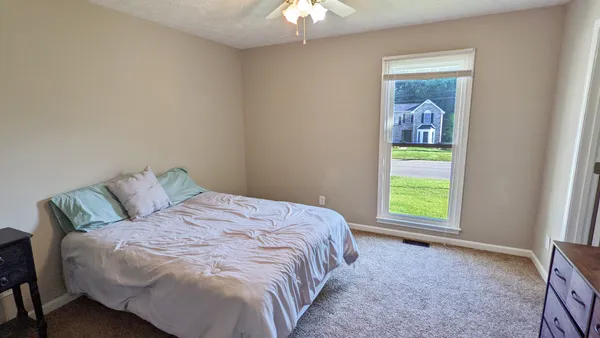 an empty room with windows and fan