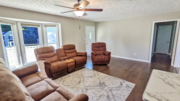 a living room with furniture ceiling fan and a window
