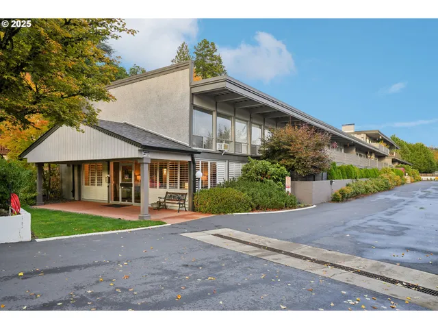 a front view of a house with a yard and potted plants