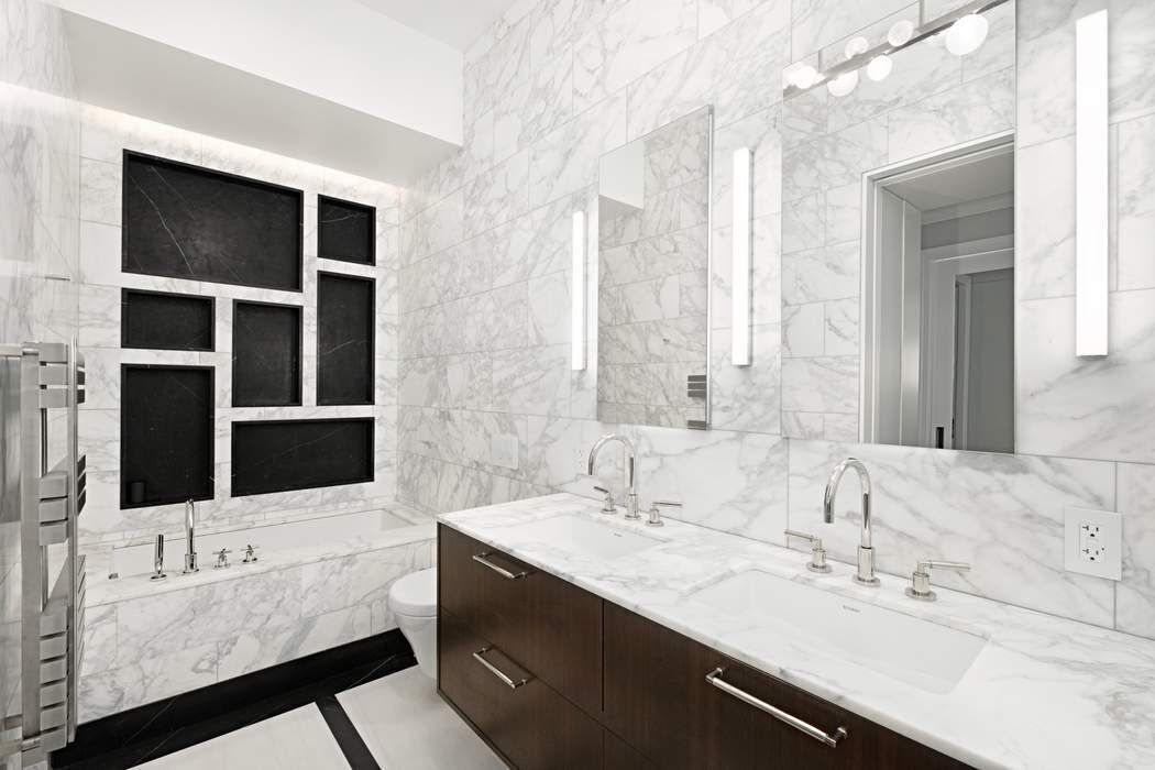910 5th Avenue, Unit 7C Manhattan, NY 10021 - Photo 8 of 15 a bathroom with a double vanity sink and mirror