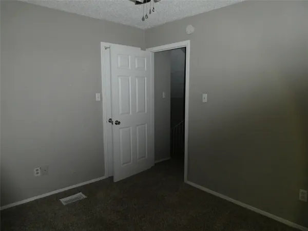 an empty room with a fan and a ceiling fan