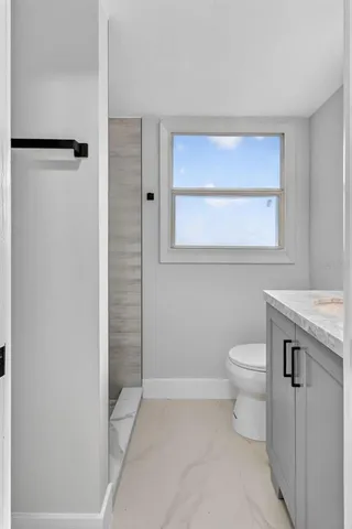 a bathroom with a toilet a sink and shower