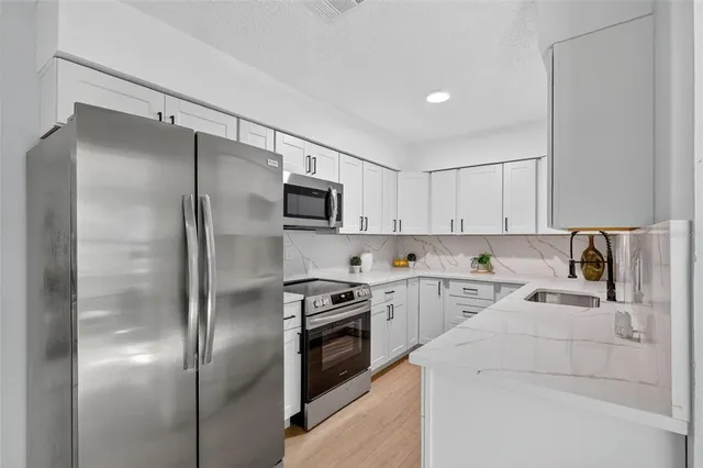 a kitchen with a refrigerator sink and cabinets