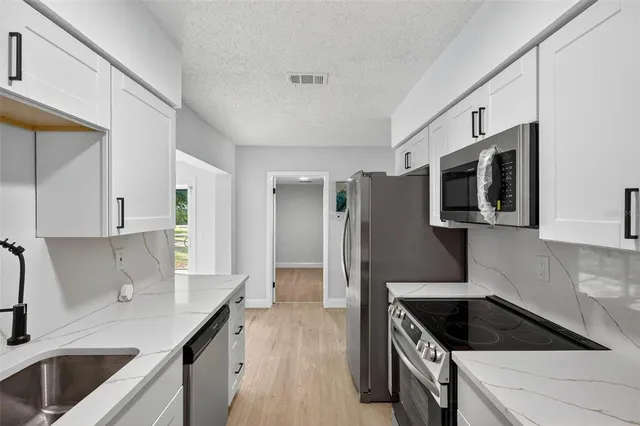 a kitchen with kitchen island stainless steel appliances a sink stove and refrigerator