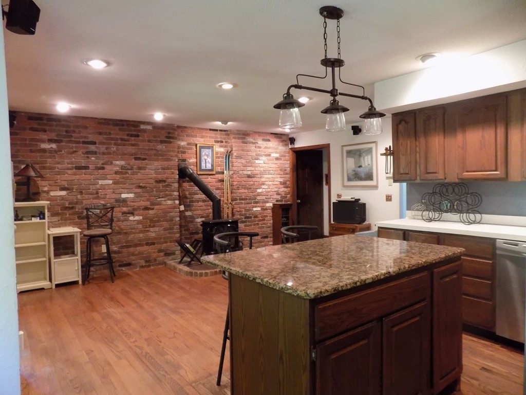 214 Podunk Road Sturbridge, MA 01566 - Photo 8 of 20 a kitchen with kitchen island a counter top space a sink stainless steel appliances and cabinets