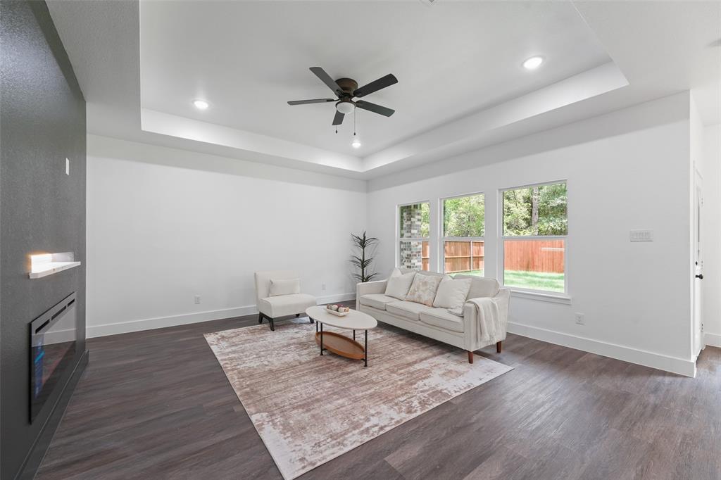 122 East Beachwood Loop Trinidad, TX 75163 - Photo 7 of 35 Spacious living area featuring wood-finish flooring, a tray ceiling with recessed lighting, and a ceiling fan