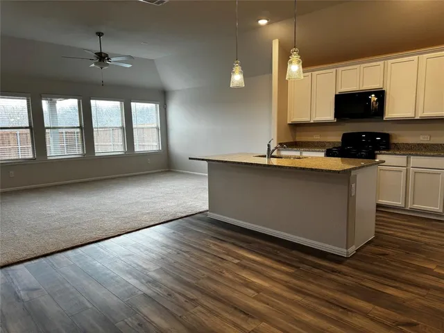 a view of kitchen with wooden floor and electronic appliances