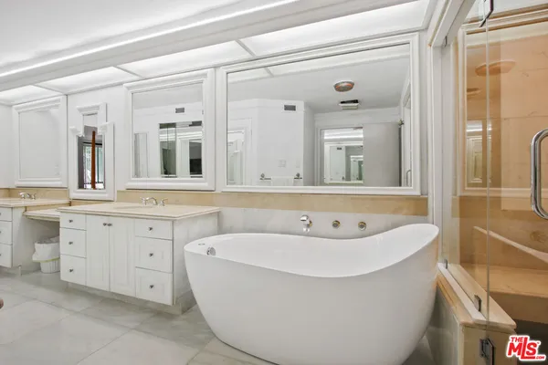 a spacious bathroom with a bathtub sink and mirror