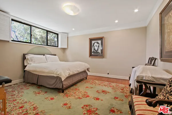 a bedroom with a bed and a painting on the wall