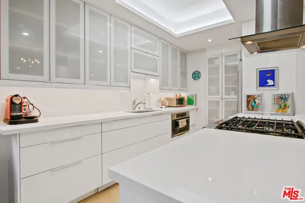 a kitchen with a stove a sink and cabinets