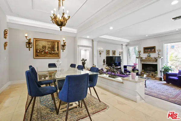 a view of a livingroom with furniture a chandelier and wooden floor