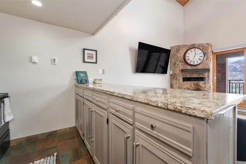 a kitchen with granite countertop a sink and a stove with wooden floor