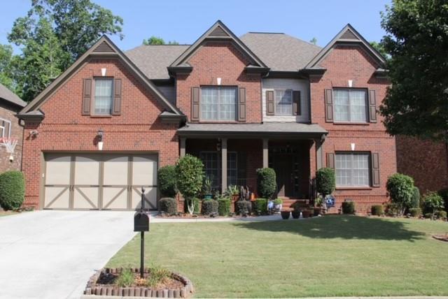 a front view of a house with a yard and garage