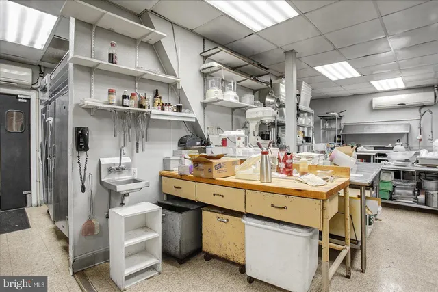 a room with stainless steel appliances kitchen island granite countertop lots of clutter and stainless steel appliances