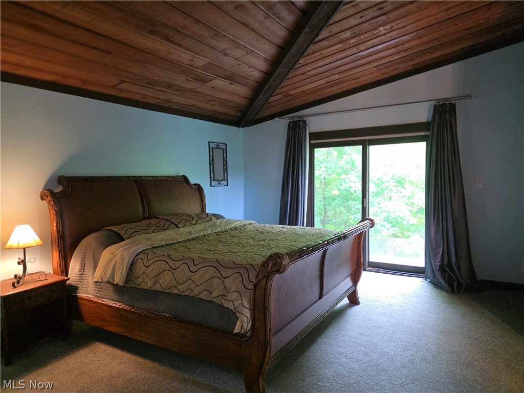 2868 Shade Road Akron, OH 44333 - Photo 37 of 49 Vaulted wood-paneled ceiling with exposed beams, sliding glass door, and neutral-toned carpeting