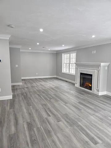 an empty room with wooden floor and fireplace