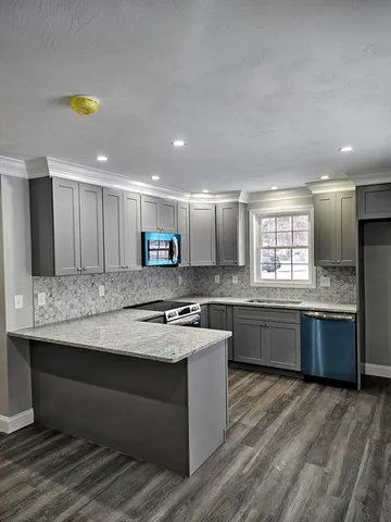 a kitchen with stainless steel appliances granite countertop a stove a sink and a refrigerator