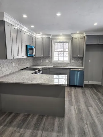 a large kitchen with kitchen island a sink stainless steel appliances and cabinets