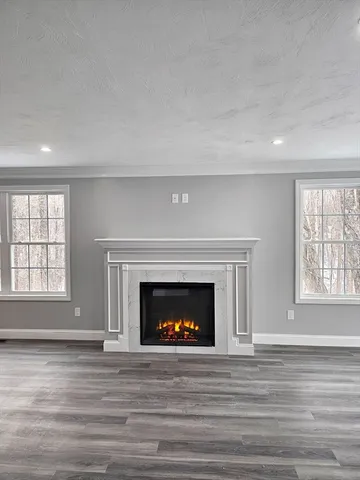 a living room with a fireplace and wooden floor