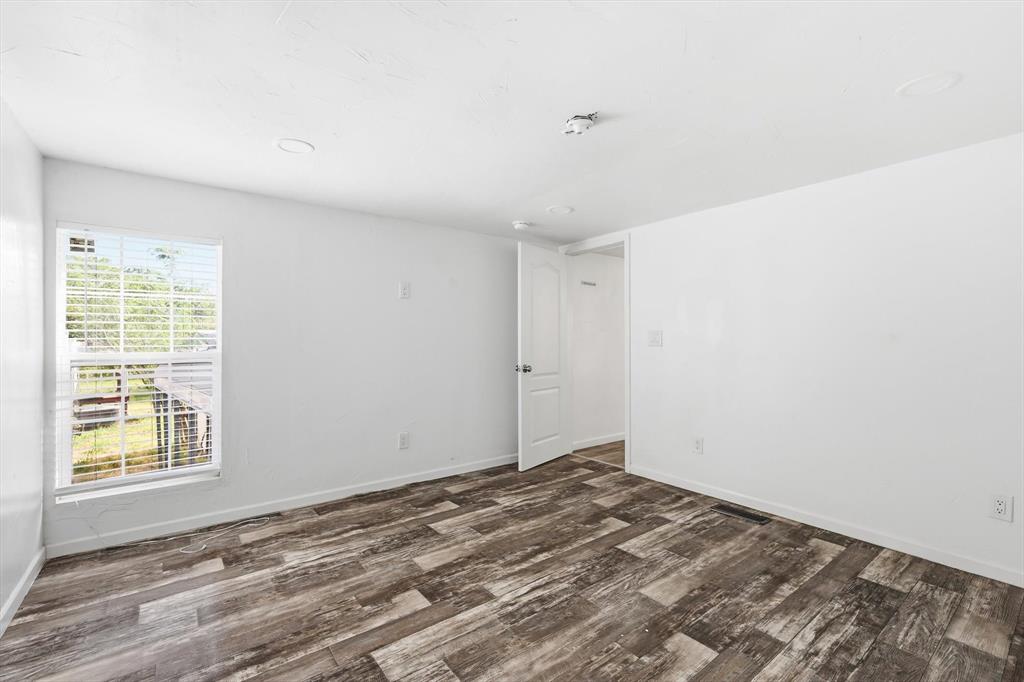 316 Summit Drive Springtown, TX 76082 - Photo 24 of 39 The property features neutral white walls, wood-look flooring, and a large window with blinds that provides natural light